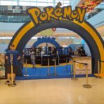Uma arena pequena com 2 filas - uma de cada lado - e um arco de entrada. Sobre o arco está escrito "Pokémon".